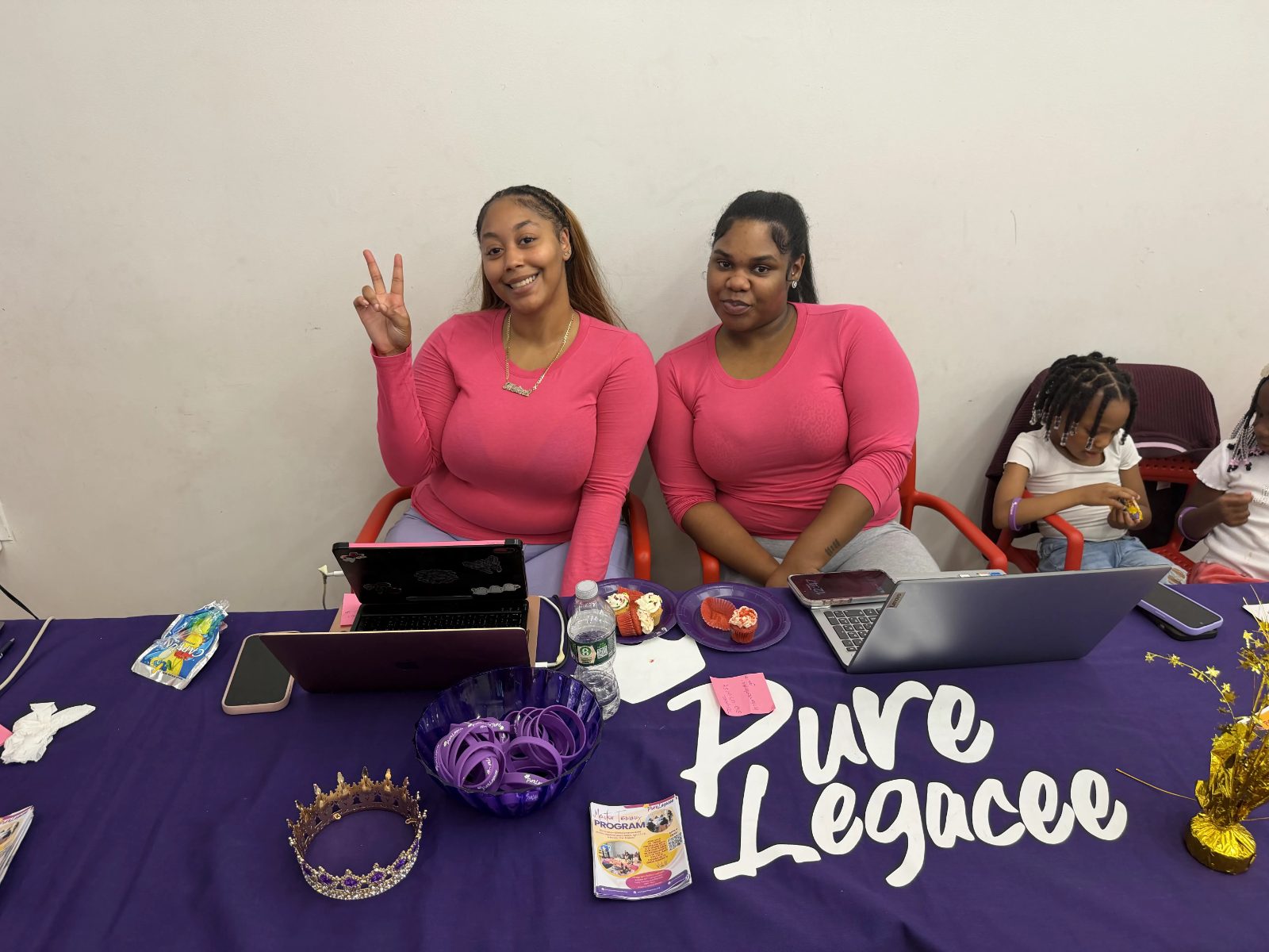 Two young women working on laptops at a PureLegacee table
